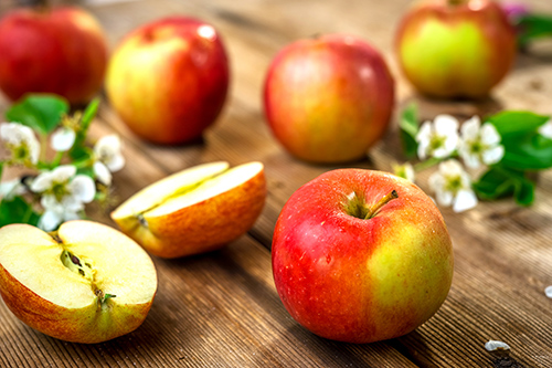 apples on a table with one cut in half